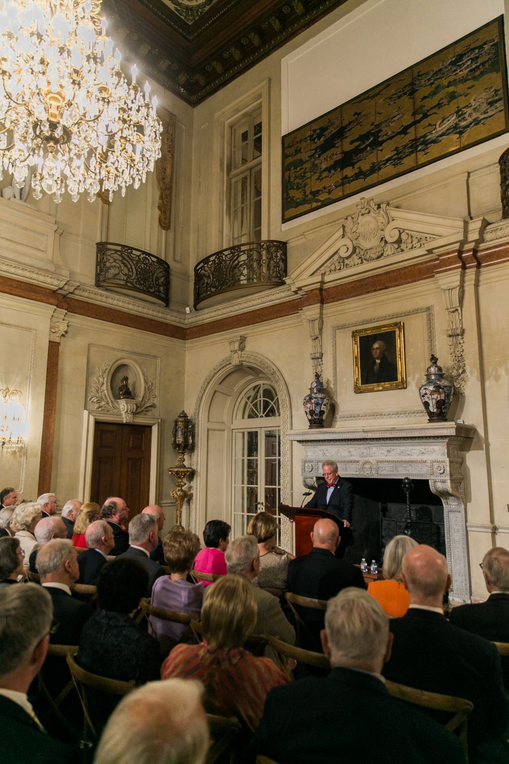 Lecturer at the fireplace in the Ballroom. Photo by Jeremy Chou.