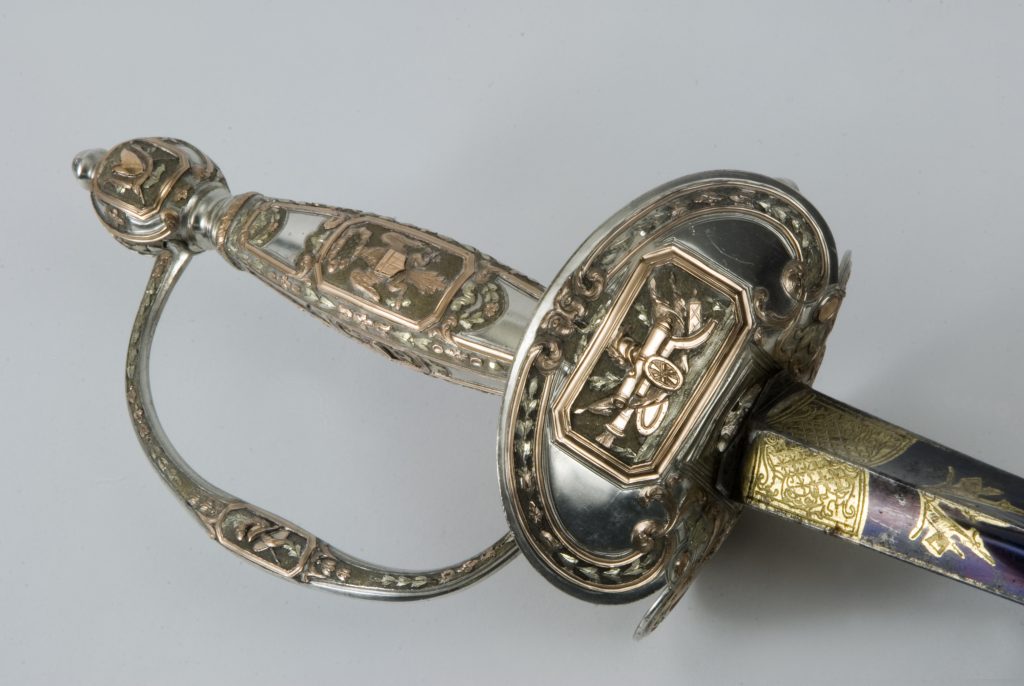 Angled detail of a silver and gold presentation sword hilt