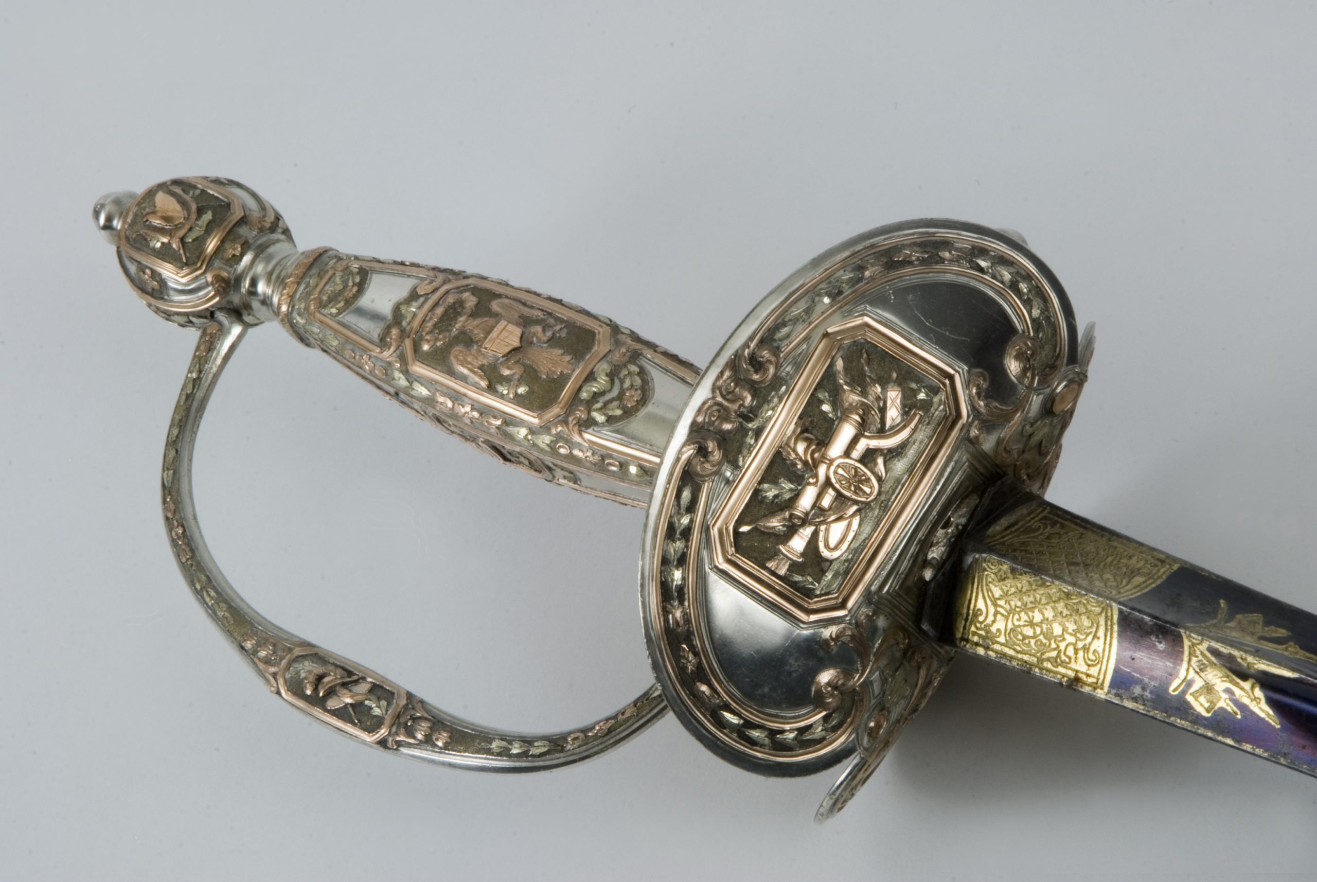 Angled detail of a silver and gold presentation sword hilt