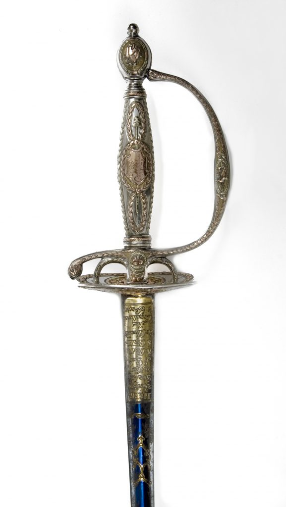 Vertical detail of the silver and gold hilt of a presentation sword