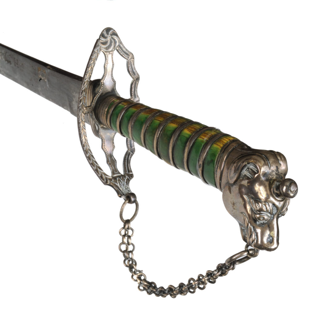 Hilt of a sword with a green-stained grip and silver dog's head pommel