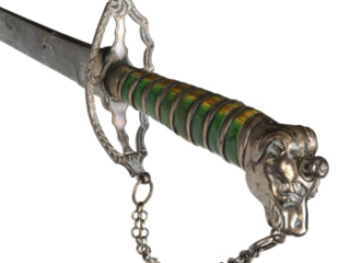 Hilt of a sword with a green-stained grip and silver dog's head pommel