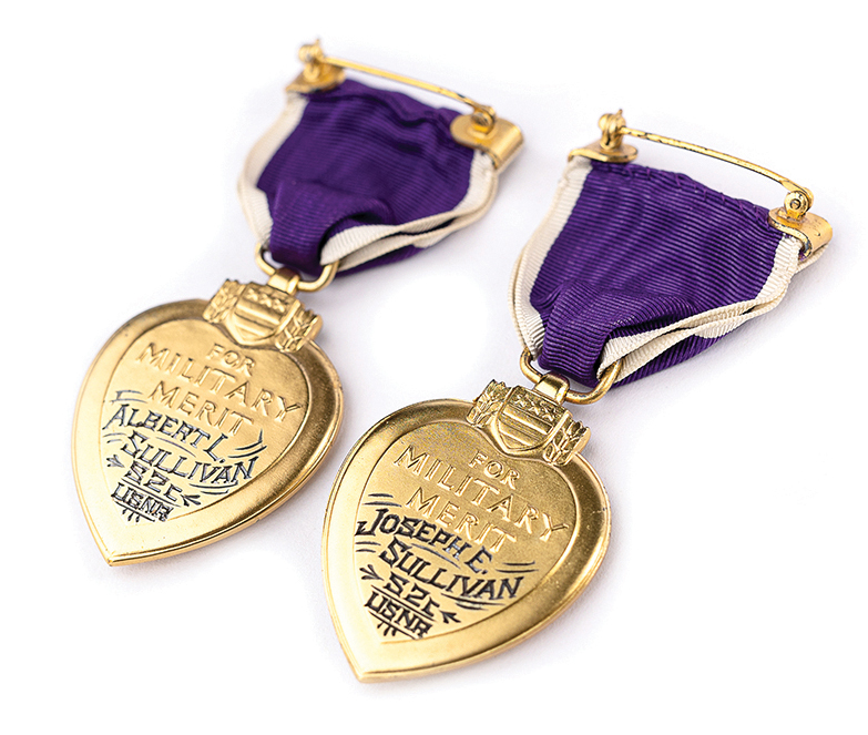Reverse of two Purple Heart medals engraved with the names of the recipients, Albert L. and Joseph E. Sullivan