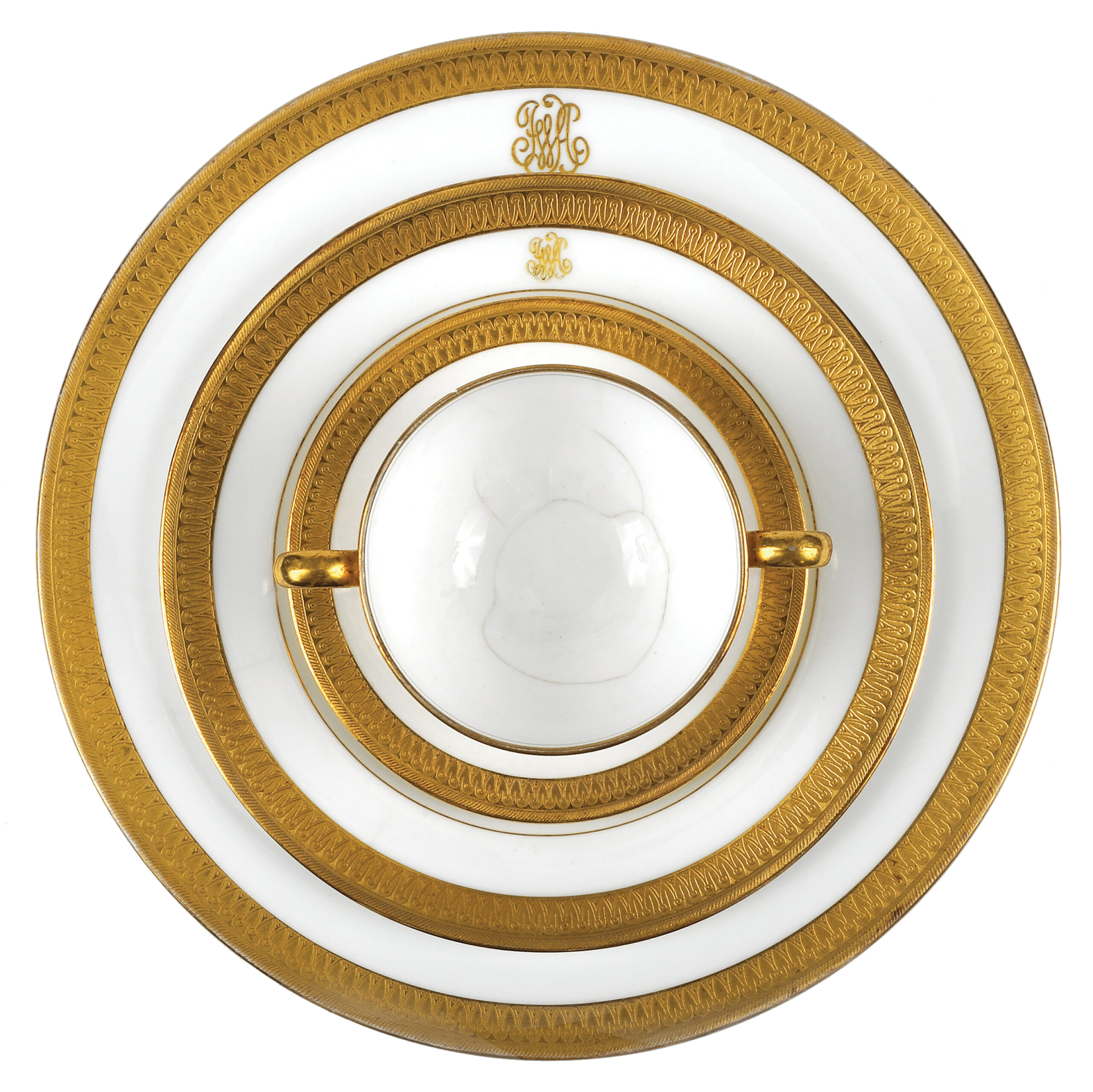 Three circular gold-and-white plates of different sizes stacked