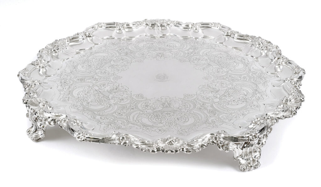 Ornate circular silver tray with feet