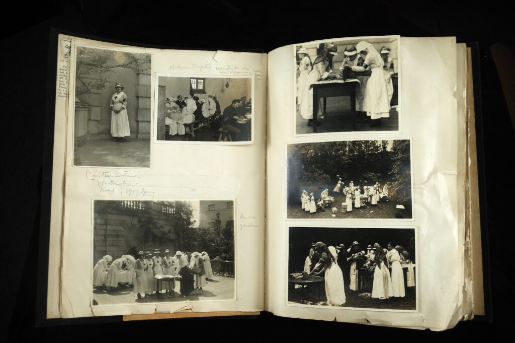 Scrapbook open to photographs of Red Cross volunteers working in a garden