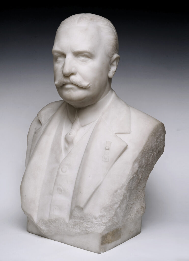 Marble bust of a man with a mustache wearing a suit and medal