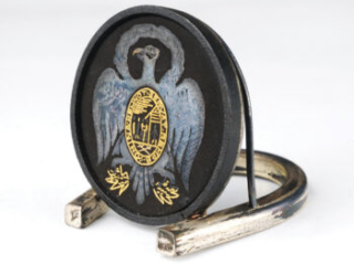 Click for a larger view. Black circular place card holder bearing a silver and gold image of an eagle